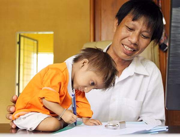 Thầy Cương dạy K'Rể tập viết