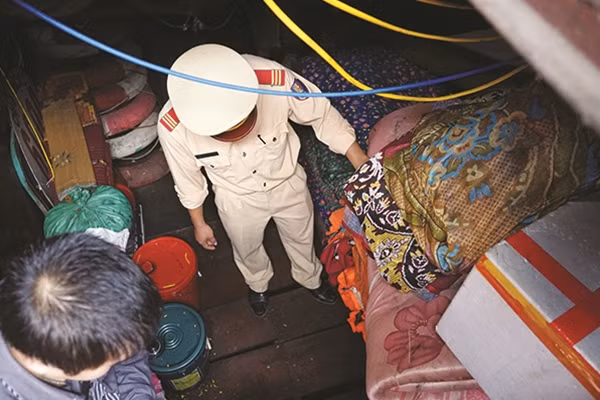 Người lính trẻ đang kiểm tra áo phao dự phòng trên một tàu chở khách. Đây là một công tác quan trọng để đảm bảo an toàn cho người dân khi tham gia giao thông đường thuỷ.