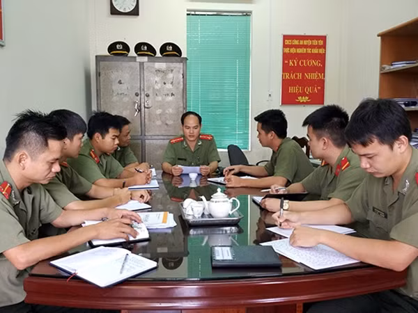 Đại úy Sằn A Phật (ngồi giữa) trong một lần họp tổ công tác giải quyết vụ việc đảm bảo an ninh trật tự từ cơ sở.