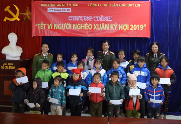 Đại diện Báo CAND cùng đại diện Công an tỉnh Lào Cai trao quà Tết tới học sinh nghèo hiếu học xã Sa Pả.