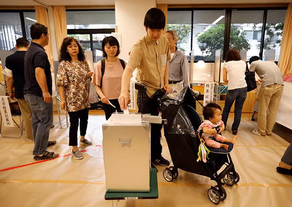 Người dân xếp hàng bỏ phiếu tại điểm bỏ phiếu ở Thủ đô Tokyo. Ảnh: Reuters.