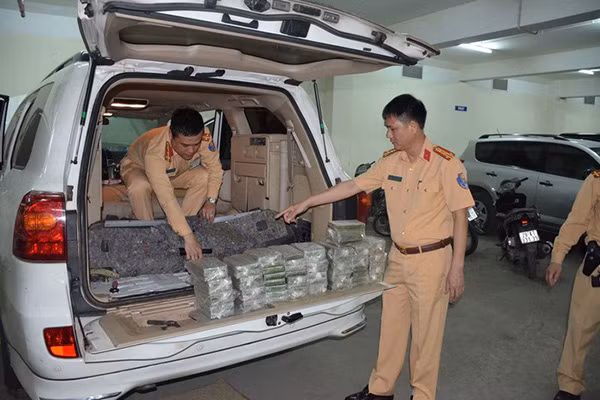 Đại tá Phạm Hồng Sơn bên số tang vật bị bắt giữ.