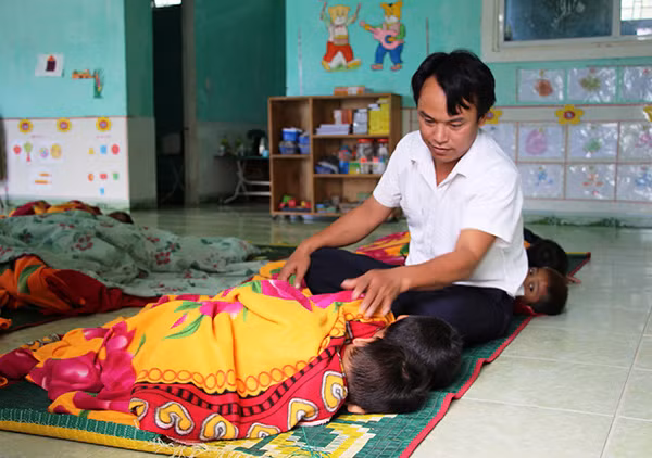 Thầy Thụn chăm sóc các cháu học sinh tại trường.