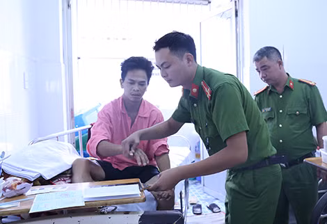 Cán bộ Phòng Quản lý hành chính về trật tự xã hội Công an tỉnh Đắk Nông làm thủ tục cấp giấy chứng minh nhân dân cho công dân Nguyễn Đức Huy tại Bệnh viện Chợ Rẫy, TP Hồ Chí Minh.