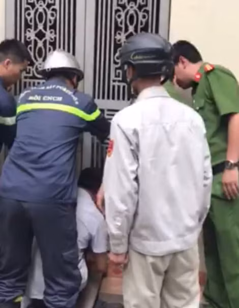Các cán bộ Công an phá khóa cửa đưa đối tượng ra ngoài.