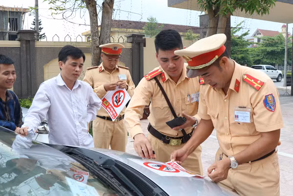 Cán bộ, chiến sỹ Công an TP Hà Tĩnh dán logo không sử dụng rượu, bia khi điều khiển phương tiện trên xe taxi.