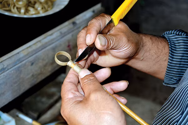 Nghệ nhân Ya Tuất tạo mẫu nhẫn bằng sáp ong.