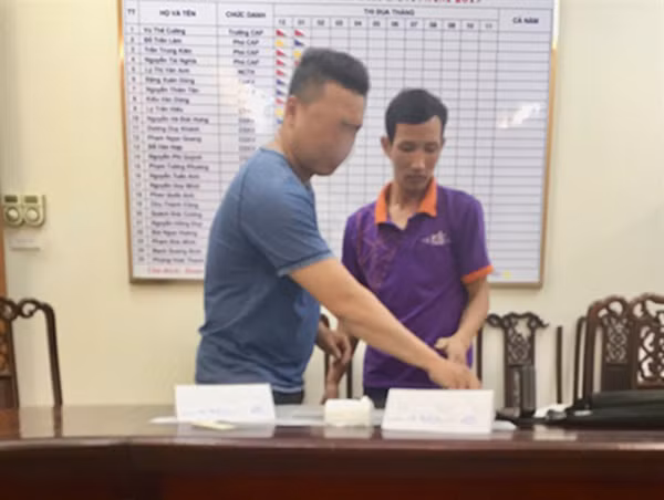 Lái xe taxi Vic Đoàn Thanh Sơn (bên phải) tại cơ quan Công an.