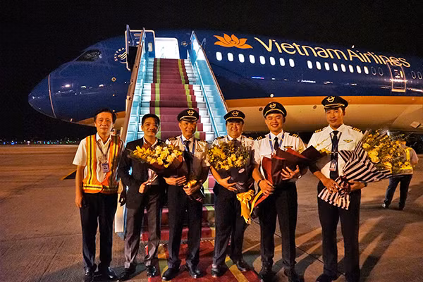 Tổ bay hoàn thành nhiệm vụ nhận tàu bay Boeing 787-10 Dreamliner đầu tiên của Việt Nam nhận hoa chúc mừng.