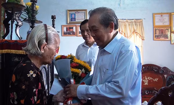 Phó Thủ tướng Thường trực Chính phủ Trương Hòa Bình tặng hoa Mẹ Việt Nam anh hùng Nguyễn Thị Ngày.
