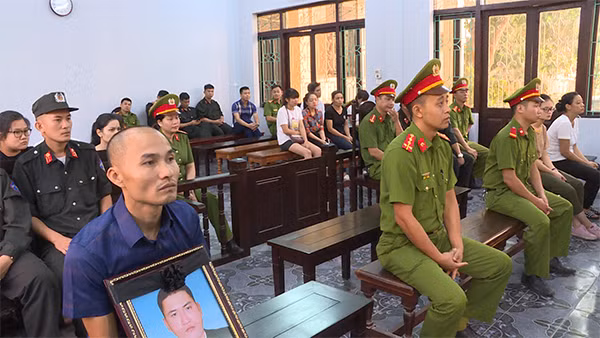 Gia đình nạn nhân cùng di ảnh của nạn nhân tại tòa.
