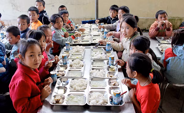 Các em học sinh ăn bữa trưa cho các thành viên trong đoàn chuẩn bị.