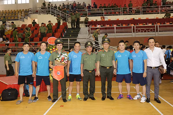 Thứ trưởng Lương Tam Quang chụp ảnh lưu niệm cùng các vận động viên Đội Bóng bàn Cục Truyền thông CAND.