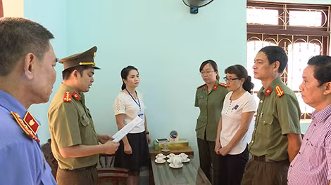Bà Nguyễn Thị Hồng Nga (áo trắng đeo kính) - chuyên viên phòng khảo thí và quản lý chất lượng, Sở GD-ĐT Sơn La nghe lệnh bắt (Ảnh: Xuân Trường).