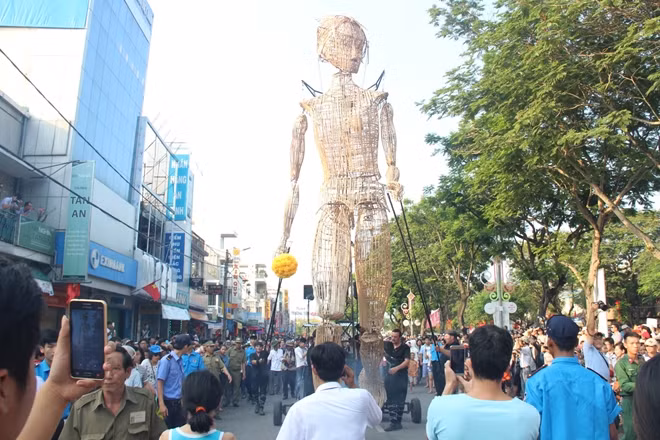Người dân địa phương và du khách đổ ra đường phố ngắm nhìn chú rối khổng lồ.