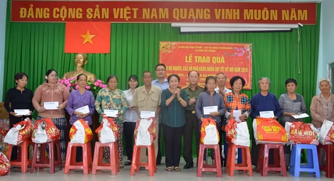 Đại tá Trần Kim Thẩm và lãnh đạo Đảng ủy, chính quyền xã Xuân Thới Thượng tặng quà cho bà con hộ nghèo, hộ khó khăn.