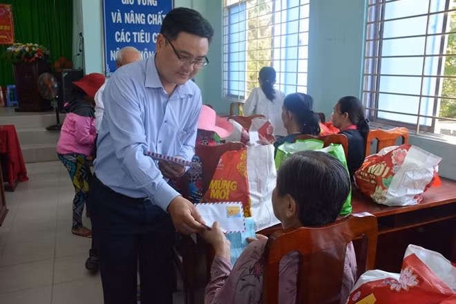 Ông Nguyễn Tuấn Anh, Bí thư Đảng ủy, Chủ tịch UBND xã Xuân Thới Thượng tặng quà cho người nghèo.