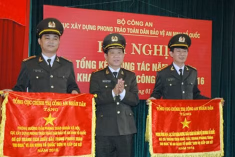 Thiếu tướng Nguyễn Văn Sơn, Phó Tổng cục trưởng Tổng cục Chính trị CAND trao Cờ thi đua của Tổng cục Chính trị CAND cho tập thể xuất sắc 8 - Trung tướng Nguyễn Văn Khảo, Cục trưởng Cục Xây dựng Phong trào Toàn dân bảo vệ ANTQ phát động phong trào thi đua năm 2016