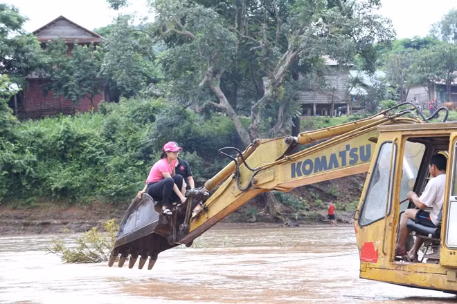 Thí sinh Hoa hậu Việt Nam 2018 phải bám vào dây thừng, hay phải ngồi trên cần cẩu xe xúc để băng qua dòng suối chảy xiết để đến với người dân bản Nịu.