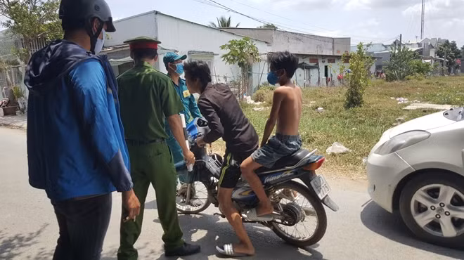 kiểm tra, nhắc nhở trẻ em chạy xe không đội non bảo hiểm và không đeo khảu trang