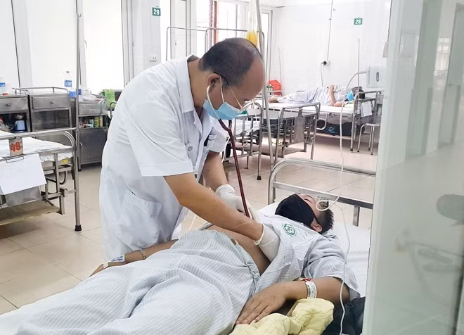 PGS.TS Nguyễn Duy Cường đang thăm khám cho bệnh nhân. (Mai Thanh)