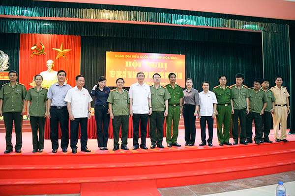 Đồng chí Đinh Thế Huynh, Ủy viên Bộ Chính trị, Bí thư Trung ương Đảng, Trưởng ban Tuyên giáo Trung ương cùng đại biểu Quốc hội tỉnh Hòa Bình và các cử tri Công an tỉnh. Ảnh: Nguyễn Hùng.