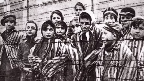 Tù nhân trẻ em phía sau hàng rào trại Auschwitz.