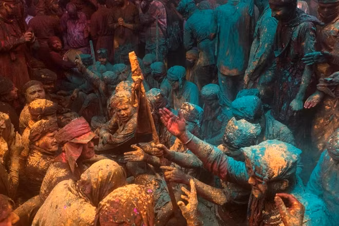 Các tín đồ theo đạo Hindu tham gia một buổi lễ truyền thống có tên Lathmar Holi - lễ hội sắc màu mùa xuân tại một ngôi đền ở làng Barsana, Ấn Độ. Ảnh: Xavier Galiana/Getty Images.
