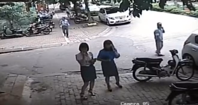 Hình ảnh trích xuất từ camera cho thấy bà Trang (bên phải) gọi điện thoại trước khi vào quán