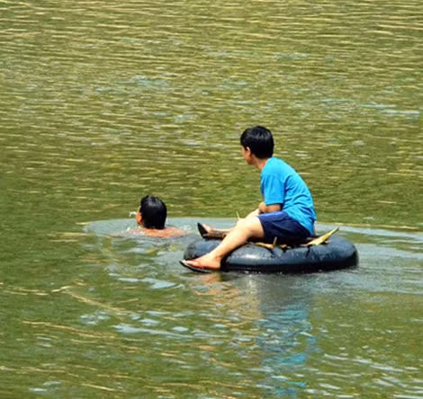 Người dân làng Tắc Rối dùng ruột xe bơm căng làm phương tiện vượt sông.