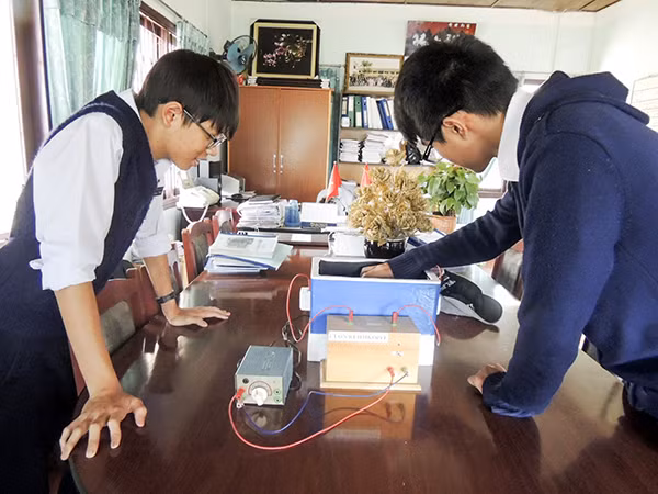 Hai học sinh Bảo Khang và Thanh Hải bên thiết bị quan sát sự chuyển động của hạt phóng xạ.