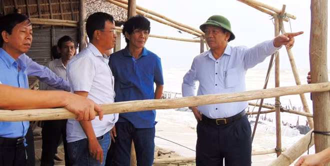 Ông Đinh Văn Thu kiểm tra tình trạng sạt lở quanh khu vực nhà hàng của bà Nguyễn Thị Chiên, chủ một nhà hàng ở phường Cửa Đại, TP Hội An. Theo bà Chiên, chỉ trong 3 ngày đêm, biển Cửa Đại sạt lở sâu vào đất liền hơn 5m. Trước đây, quán của bà Chiên cách mực nước biển vài chục mét nhưng hiện đứng trước nguy cơ bị sóng cuốn trôi ra biển.