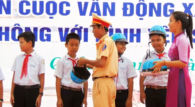 Đại diện CSGT tỉnh Quảng Nam tặng mũ bảo hiểm cho học sinh Hội An.