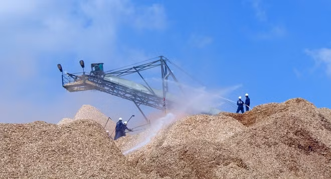 Lực lượng chữa cháy cơ sở tập trung dập tắt đám cháy tại khu vực tập kết dăm gỗ.