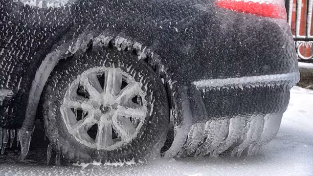 Băng phủ kín một chiếc xe ô tô trên đường phố Vladivostok. Ảnh: Reuters.