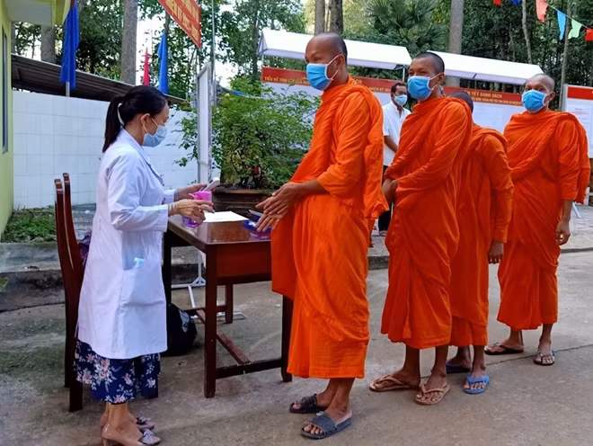Các cử tri thực hiện nghiêm biện pháp phòng chống dịch COVID-19, trước khi vào bỏ phiếu bầu cử.