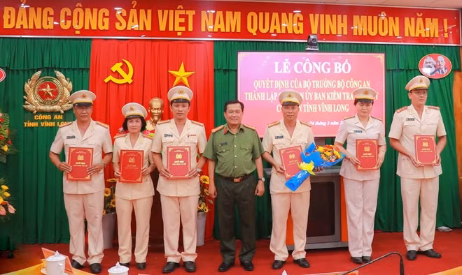 Đại tá Đoàn Minh Lý, Giám đốc Công an tỉnh Vĩnh Long trao quyết định và tặng hoa chúc mừng các đồng chí trong Cơ quan UBKT Đảng ủy Công an tỉnh.