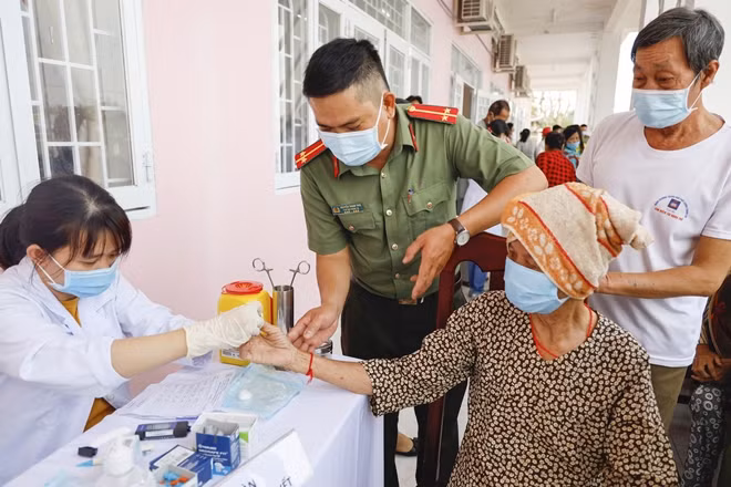 Cán bộ chiến sĩ Công an TP Cần Thơ hỗ trợ người dân đến khám bệnh.