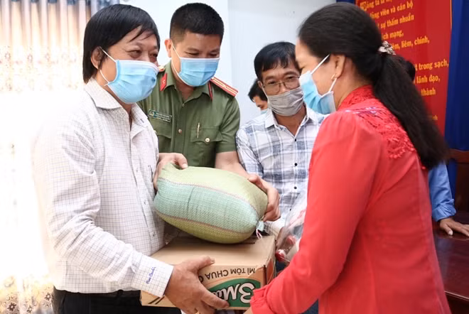 Thiếu tá Nguyễn Văn Bình cùng các nhà hảo tâm trao quà Tết cho người nghèo ở xã Mỹ Hội (huyện Cái Bè, tỉnh Tiền Giang).