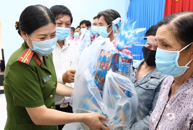 Ông Lưu Quốc Cường và Thượng tá Võ Thị Cúc, Phó trưởng Công an huyện Mỏ Cày Nam, trao quà cho người dân ở xã Phước Hiệp.