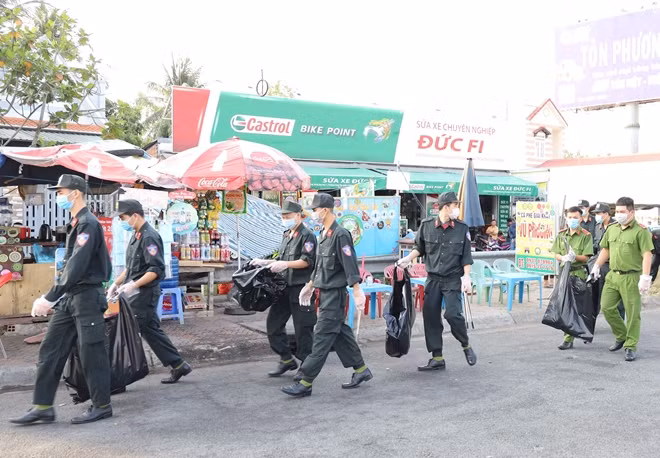 Cán bộ, chiến sĩ đang thu gom rác tại đường dẫn cầu Cần Thơ.