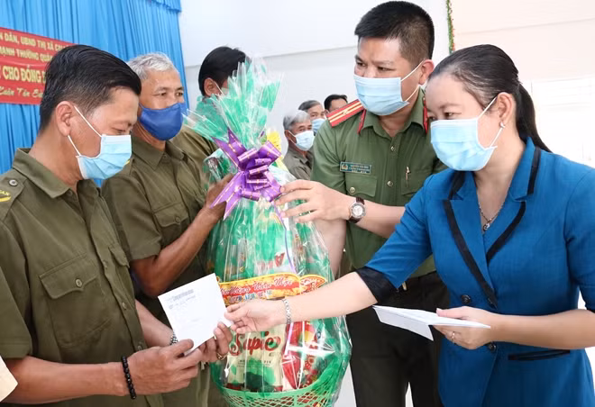 Bà Võ Thị Búp, Phó Chủ tịch UBND thị xã Cai Lậy cùng Thiếu tá Nguyễn Văn Bình, trao quà Tết cho người dân.