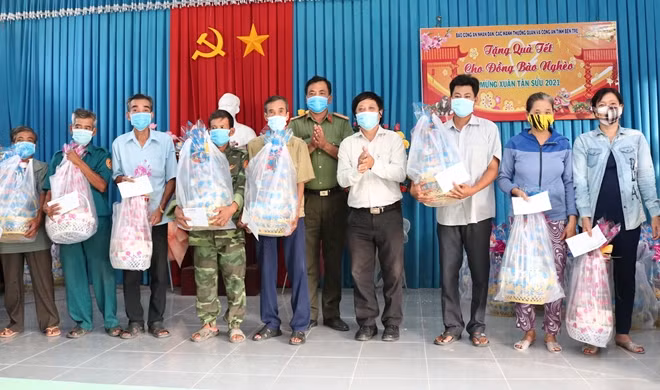 Ông Lưu Quốc Cường và đại diện Công an tỉnh Bến Tre, trao quà cho người dân.