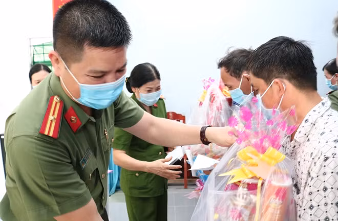 Thiếu tá Nguyễn Văn Bình và Thượng tá Võ Thị Cúc, trao quà cho người dân ở xã Bình Khánh.