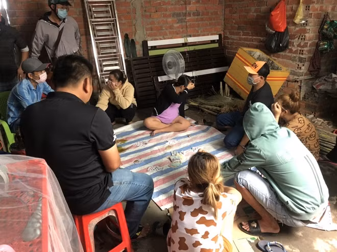 Nhóm đối tượng đánh bạc cùng tang vật tại hiện trường.