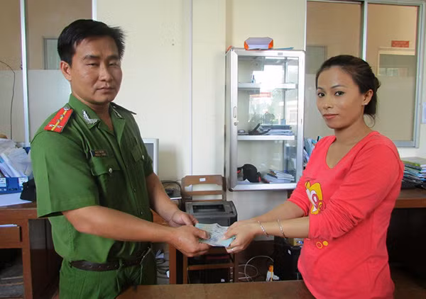 Đại úy Đặng Thế Vinh trao trả số tiền cho người dân đánh rơi.