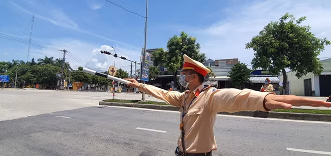 Chiến sĩ CSGT trạm cửa ô Hòa Nhơn làm nhiệm vụ phân luồng, hướng dẫn các phương tiện và người đi đường vào trạm khai báo y tế.
