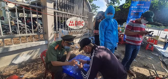 Chiến sĩ Công an quận Liên Chiểu hướng dẫn, hỗ trợ hành khách tuyến Bắc - Nam khai báo y tế điện tử khi ngang qua chốt kiểm dịch COVID -19 đường Tạ Quang Bửu (đoạn đường dẫn vào hầm Hải Vân).