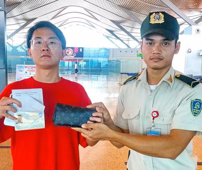 Nhân viên an ninh kiểm soát sân bay quốc tế Cam Ranh trao trả lại tài sản du khách Lou Tao Tao đánh rơi . Ảnh : HKQTCR