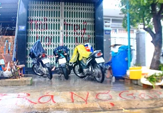 Không chỉ đe dọa tính mạng, đập phá tài sản, tạt sơn trộn lẫn mắm, cá thối trên sàn nhà, mà nhóm người đòi nợ còn dùng bình xịt sơn lên cửa sắt và lề phố trước cửa nhà ông Trần Mão. Ảnh : Doãn Công